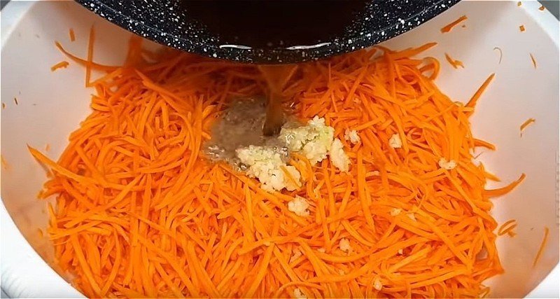 В настоявшуюся морковь добавляем уксус, чеснок и горячие специи с растительным маслом